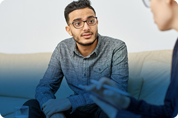 a man sitting on a couch talking to a woman