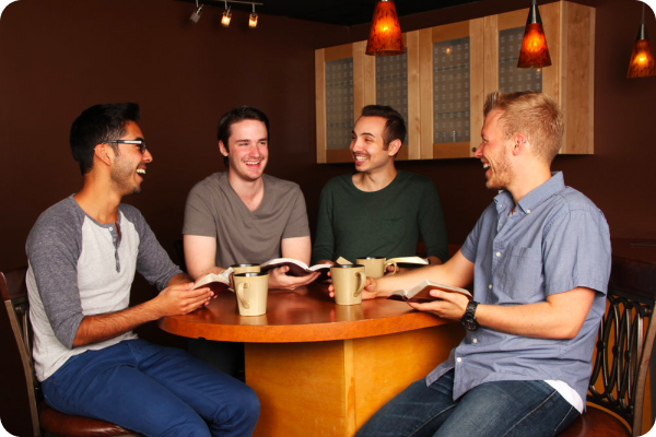 a group of men sitting around a wooden table