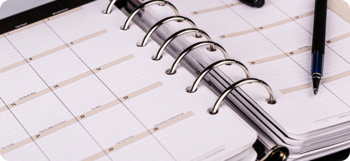 a planner with a pen on top of it